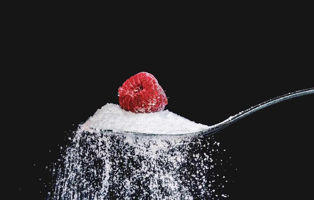 colher de açúcar com framboesa em cima representando 20 alimentos que diabéticos não podem comer constantemente